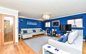 Spacious lounge area with woodturning stove and HDTV