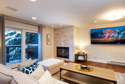 Open living room with fireplace and balcony