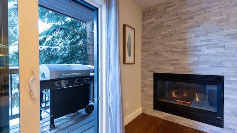 Open living room with fireplace and balcony