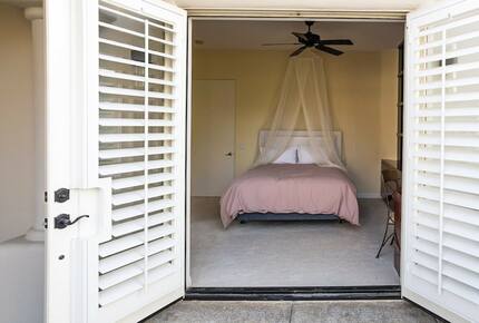 Home Exchange in La Quinta, CA guest bedroom with patio access