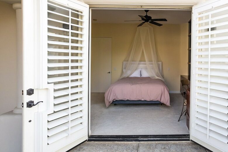 Home Exchange in La Quinta, CA guest bedroom with patio access