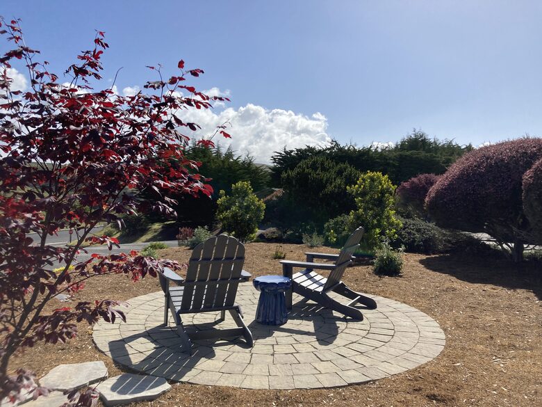 Front yard patio seating area with views of surrounding hills.