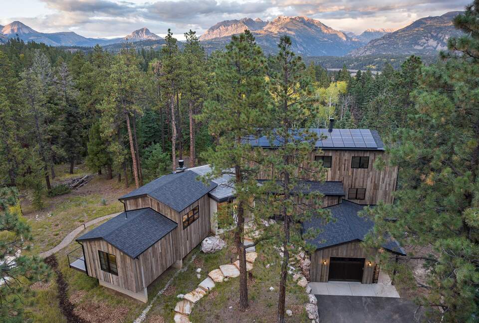 Aerial picture of front of home with mountains in the distance.