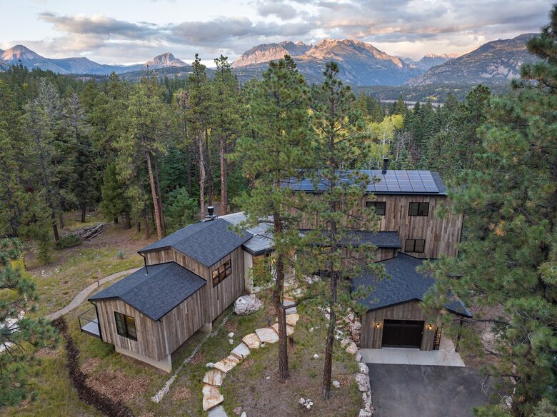 Aerial picture of front of home with mountains in the distance.