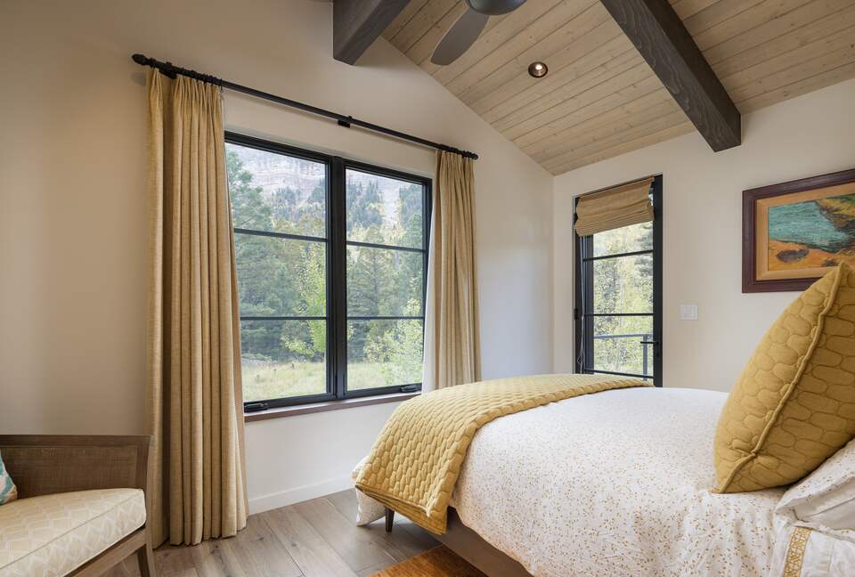 Guest room with queen bed, large windows and door to deck.
