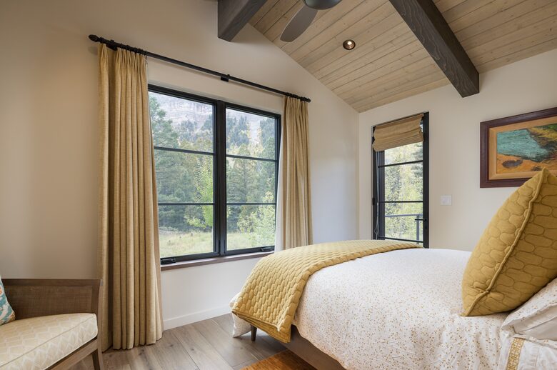 Guest room with queen bed, large windows and door to deck.