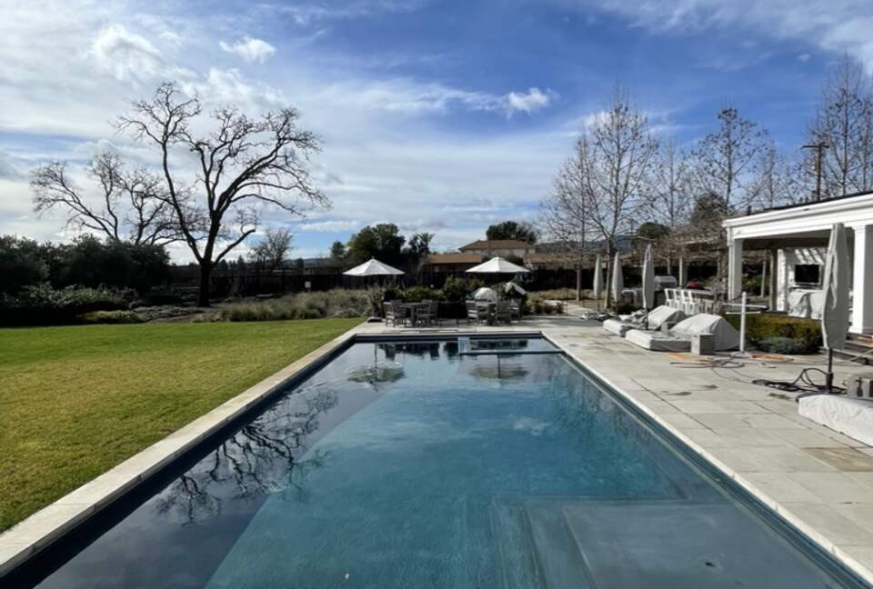 The pool and spa with lounge chairs and table seating.