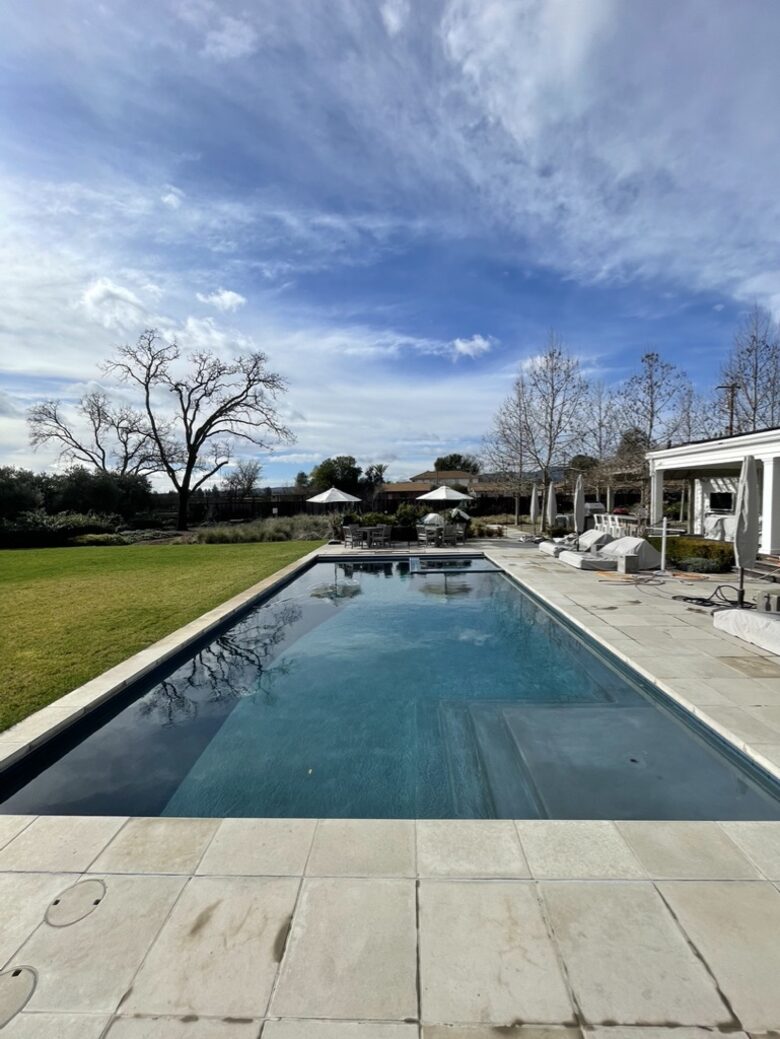 The pool and spa with lounge chairs and table seating.