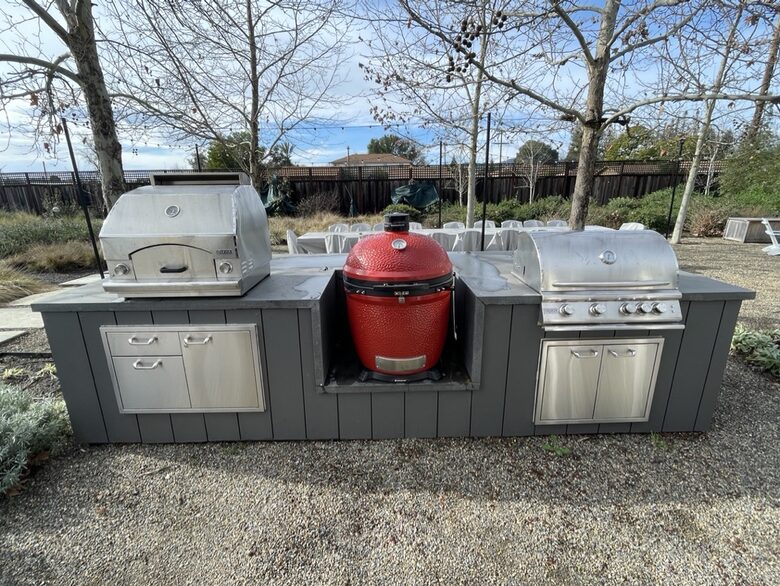 The BBQ area with pizza oven, Kamado Joe, and gas grill.