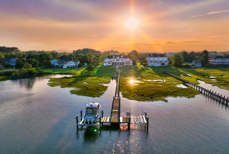 drone shot looking back at house from past the dock