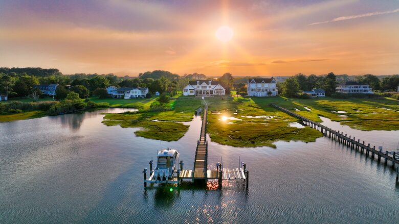 drone shot looking back at house from past the dock