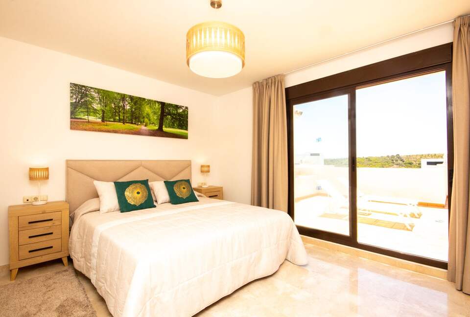 Second bedroom with comfortable high quality king bed and patio access