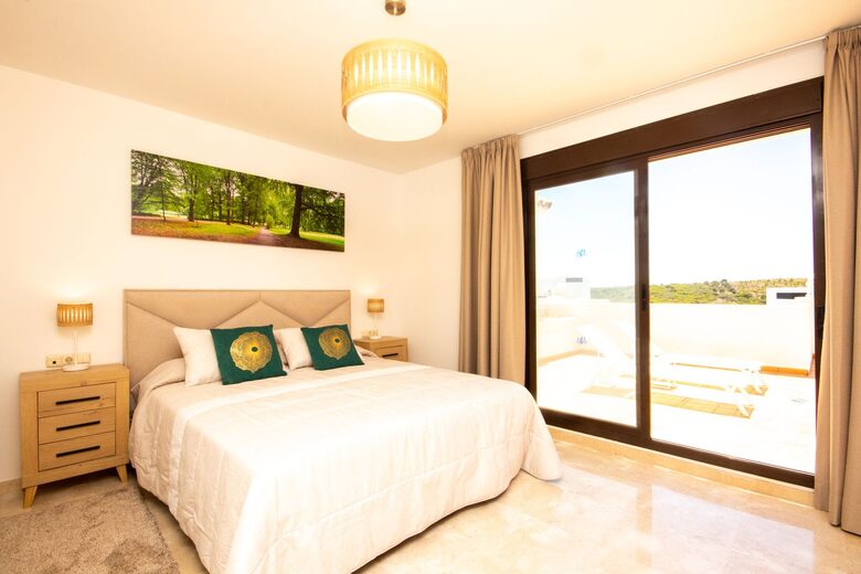 Second bedroom with comfortable high quality king bed and patio access