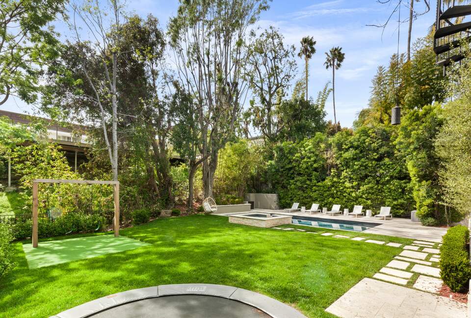 Backyard with pool, trampoline and swingset