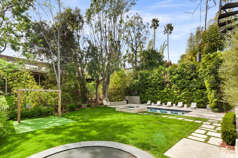 Backyard with pool, trampoline and swingset