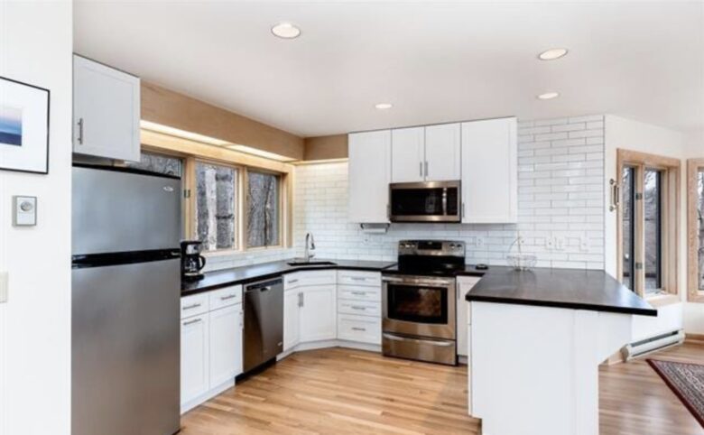 Renovated electric kitchen and bar-top seating for three.