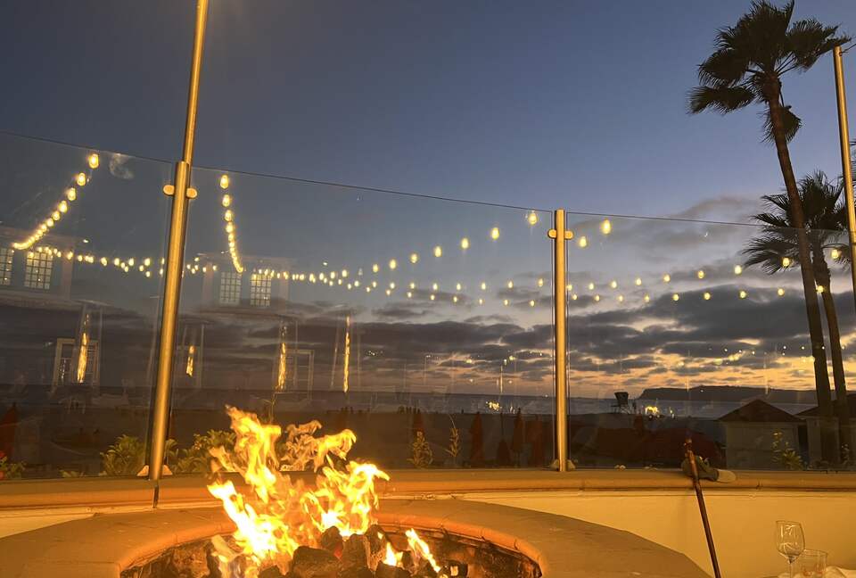 Pool deck featuring fire pits overlooking the ocean