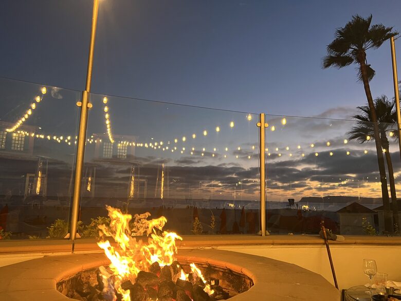 Pool deck featuring fire pits overlooking the ocean