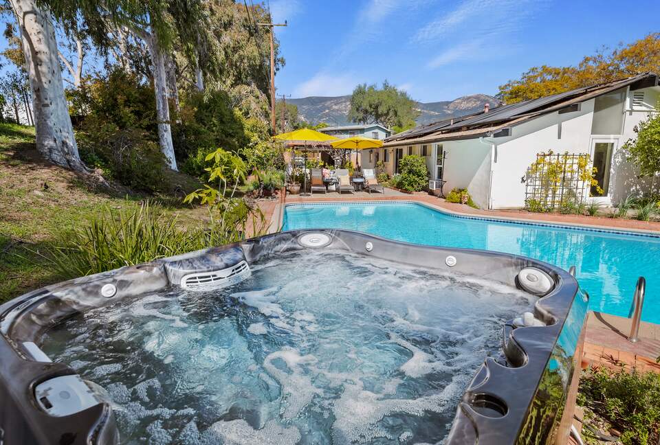 pool and hot tub with view of hills