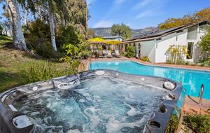 pool and hot tub with view of hills